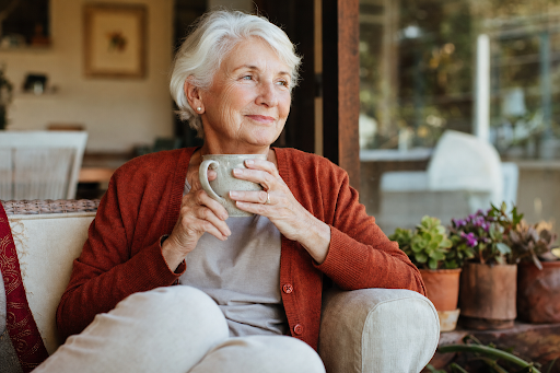 Warm photo of elderly Australian woman at home — gardening, sitting on porch